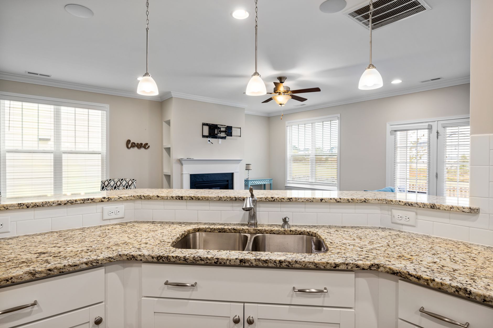 Bright kitchen interior featuring granite countertops, pendant lighting, and a spacious open layout in Riverside, CA
