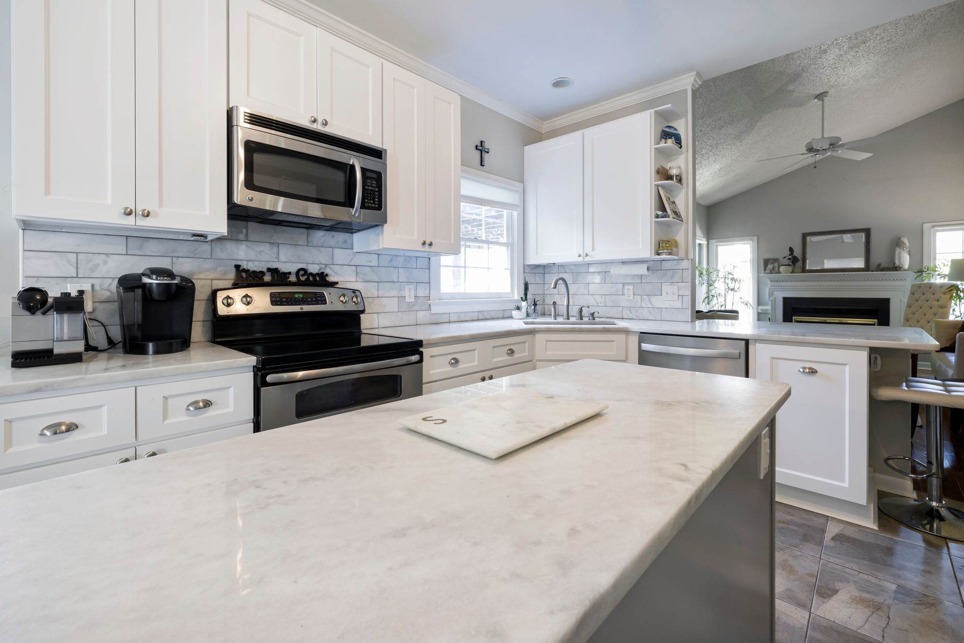Spacious modern kitchen featuring sleek white cabinets and marble countertops, perfect for a stylish home in Riverside, CA